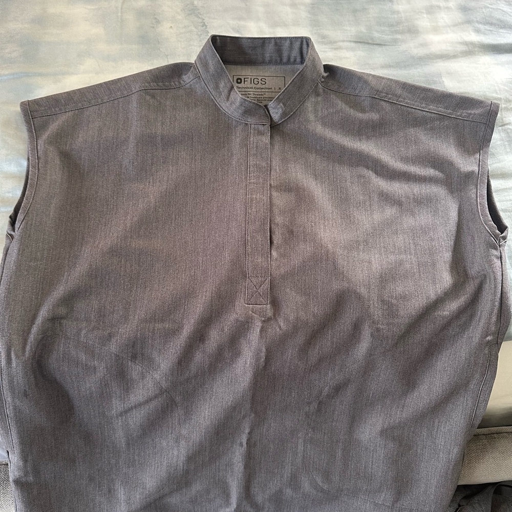 Figs small top - fits a person of Medium size very well- due to the cut